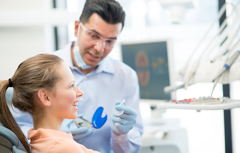 Orthodontist with patient in the dental chair.