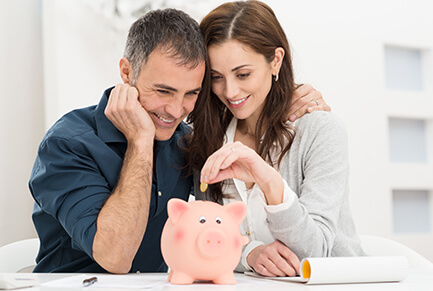 Couple putting money in a piggy bank