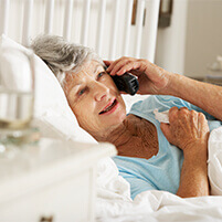 Elderly woman on phone in bed