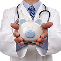 Male doctor holding piggy bank
