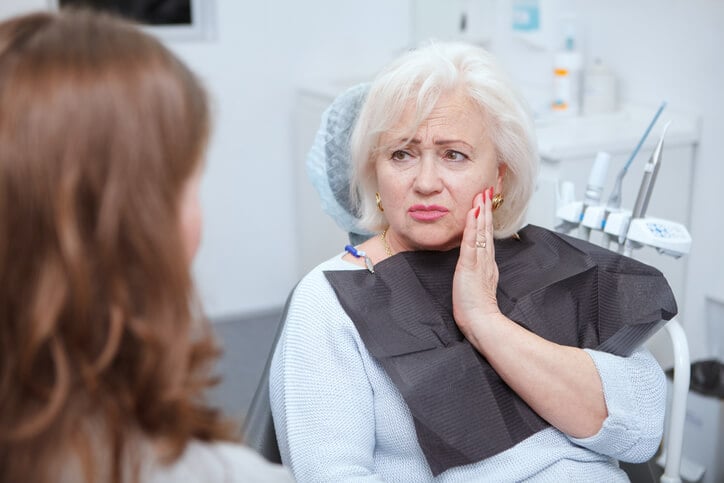 woman with mouth pain in dentist office